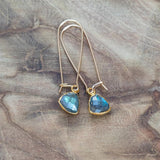 Labradorite Gold Earrings for Healing and Transformation, beautifully laid on a wood table in light.