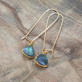 Radiant Labradorite Gold Earrings for Healing and Transformation, beautifully laid on a wood table in light.