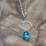 Blue topaz long silver necklace gracefully displayed, highlighting its shimmering gemstone and sleek silver design.