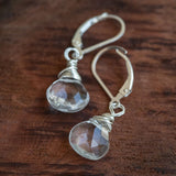 Quartz Crystal Briolette Earrings elegantly displayed on a wooden table.