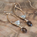 Handmade gold crystal earrings for healing, displayed beautifully on a wood table.