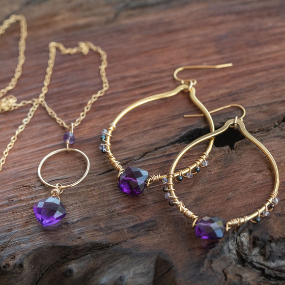 Amethyst necklace and earrings set featuring amethyst and tanzanite gemstones, elegantly laid out for display.