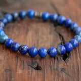 Purple Lapis Lazuli Men's Boho Style Bracelet resting on a table, showcasing its vibrant colors and natural stones.