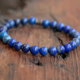 Purple Lapis Lazuli Men's Boho Style Bracelet resting on a table, showcasing its vibrant colors and natural stones.