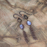 Mystic peach brown moonstone dangling earrings laid on a wood table, symbolizing inner glow and transformation.