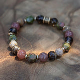 Unakite ocean jasper smoky quartz strawberry quartz and fire opal bracelet with gold accents symbolizing grounding energy and inner fire.