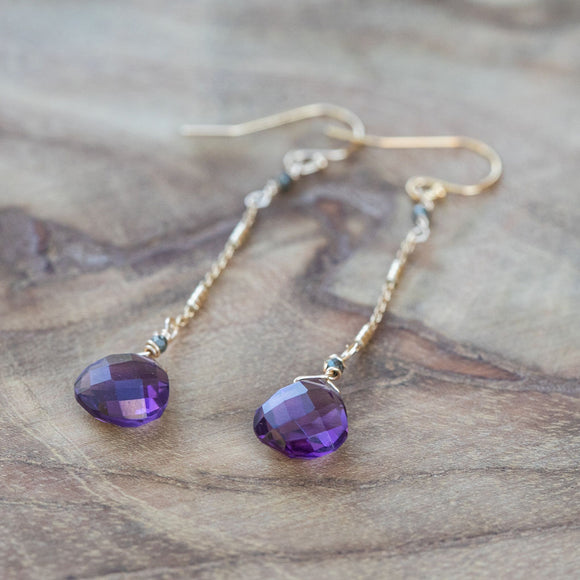 Amethyst, pyrite, and crystal earrings for chakra healing, laid beautifully on a table.