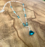 Sterling silver necklace with peacock blue trillion cut quartz pendant and hand-wrapped blue quartz accent stones.