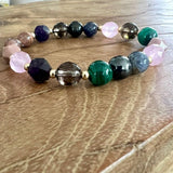 Handmade cancer support healing crystal bracelet featuring Malachite, Sugilite, Shungite, Rhodonite, Rhodochrosite, Rose Quartz, Amethyst and Iolite gemstones.