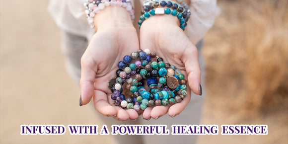 hands holding several healing bracelets